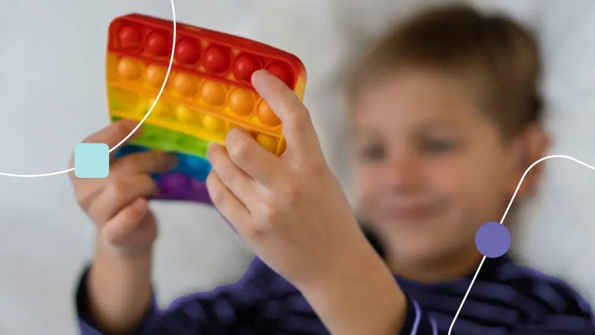 Menino com Sinais de autismo brincando com brinquedo colorido.