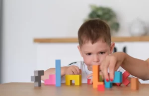 neuroplasticidade apresentada com menino brincando com blocos coloridos.