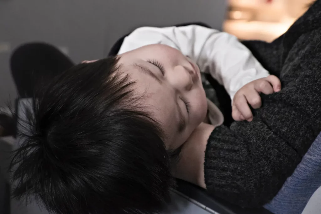 Sinais de autismo: bebê dormindo no colo da mãe