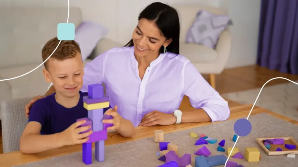 Mãe brincando com filho. Ela acompanha ele montando uma torre de bloco, brincadeira aprendida via Terapia ABA