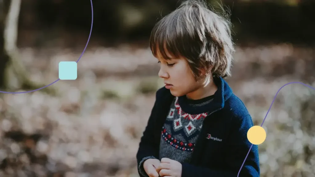 Menino com autismo severo (nível 2), olhando para baixo.