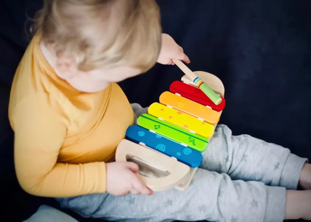 Criança sentada brincando com blocos coloridos