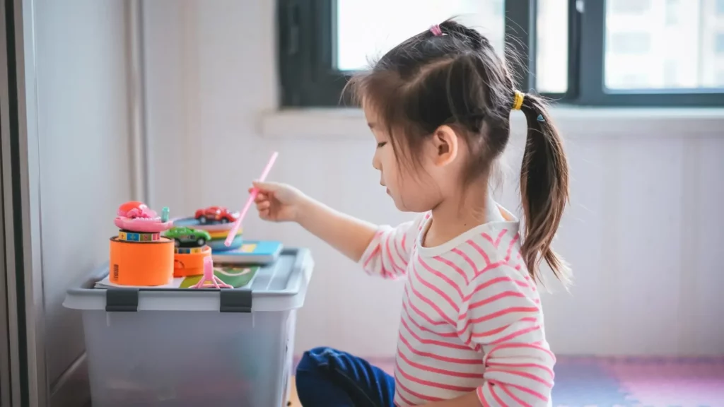 Menina brincando com brinquedos coloridos.