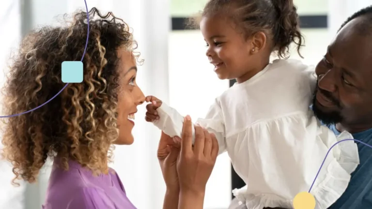 Pai segurando filha no colo e mãe praticando estratégias de behaviorismo radical