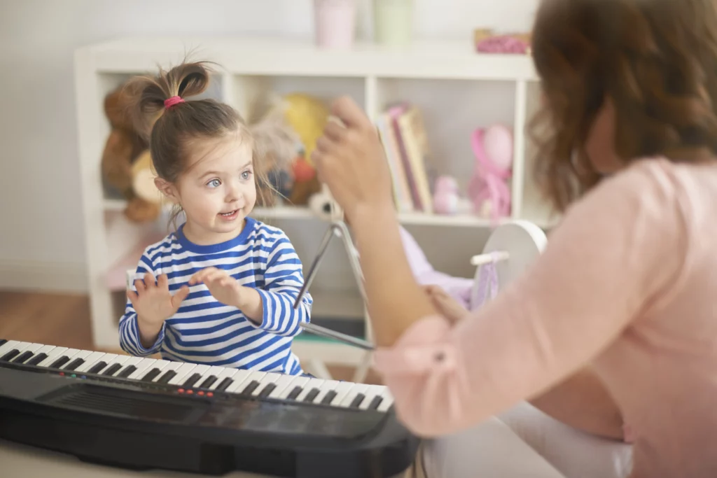 menina tocando piano com mulher 