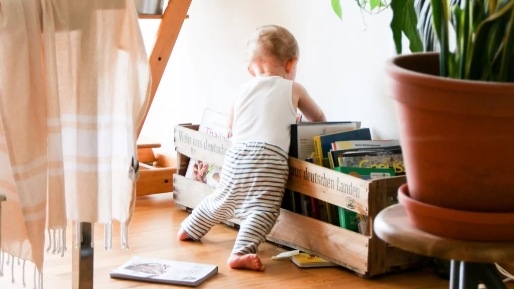 momentum comportamental: bebê está mexendo em caixa de madeira com livros