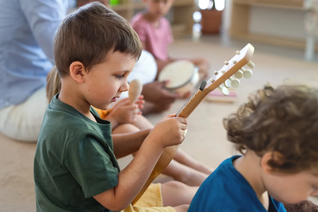 menino tocando instrumento musical em uma aula de musicoterapia