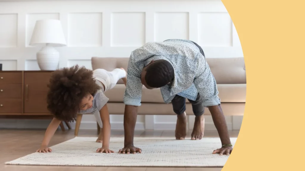 uma criança e um homem negro estão praticando alongamento em um tapeta na sala.
