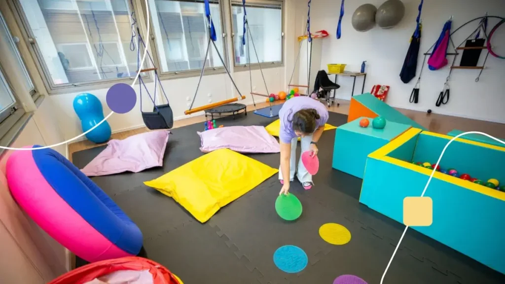 Terapeuta ajeitando a sala de integração sensorial na unidade Genial Care Morumbi.