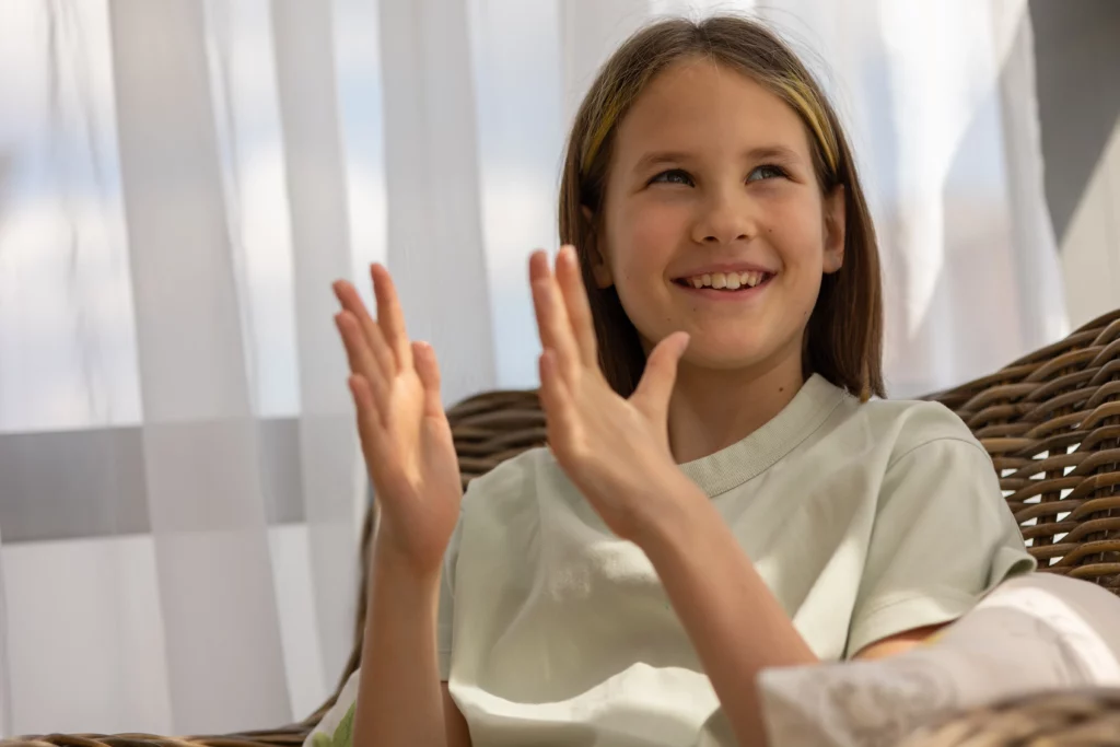 menina batendo as mãos como comportamentos estereotipados 