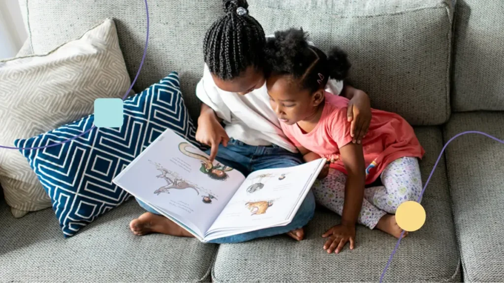 Crianças lendo livro juntas. A atenção compartilhada ao assunto é evidente, uma vez que elas estão atentas as figuras.