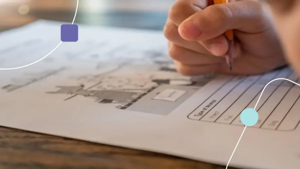 Mão segurando um lápis e preenchendo documento da Escala ABC no autismo.