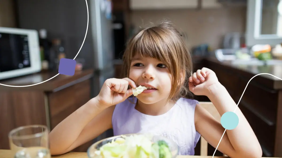 Menina autista com seletividade alimentar. Ela está comendo uma salada.