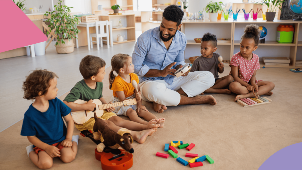 uma sala de crianças e um professor onde todos estão sentados no chão, uma das crianças está tocando um violão de madeira e o professor está com um pandeiro na mão