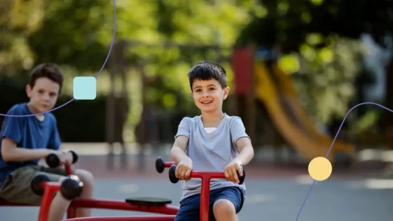 Meninos brincando em gangorra em parque. Eles fazem parte de um projeto terapêutico que trata emoções no autismo em crianças.