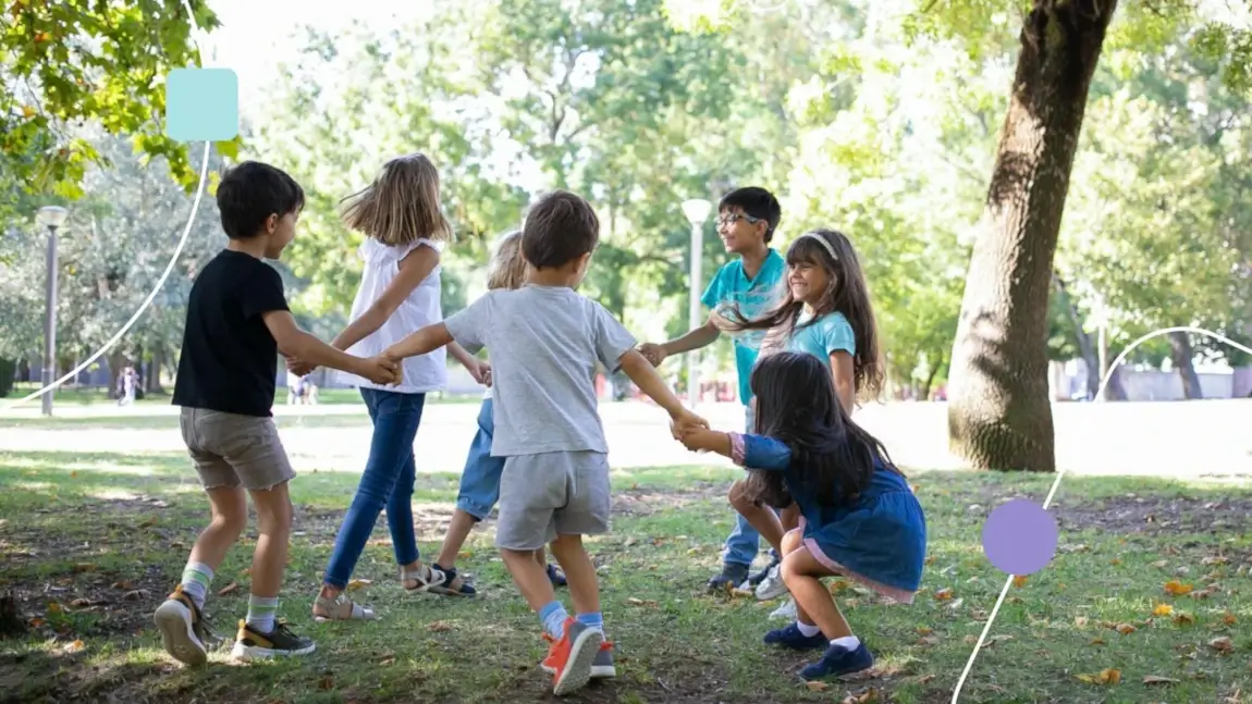 socialização de crianças com autismo em parque arborizado. As crianças brincam de ciranda.