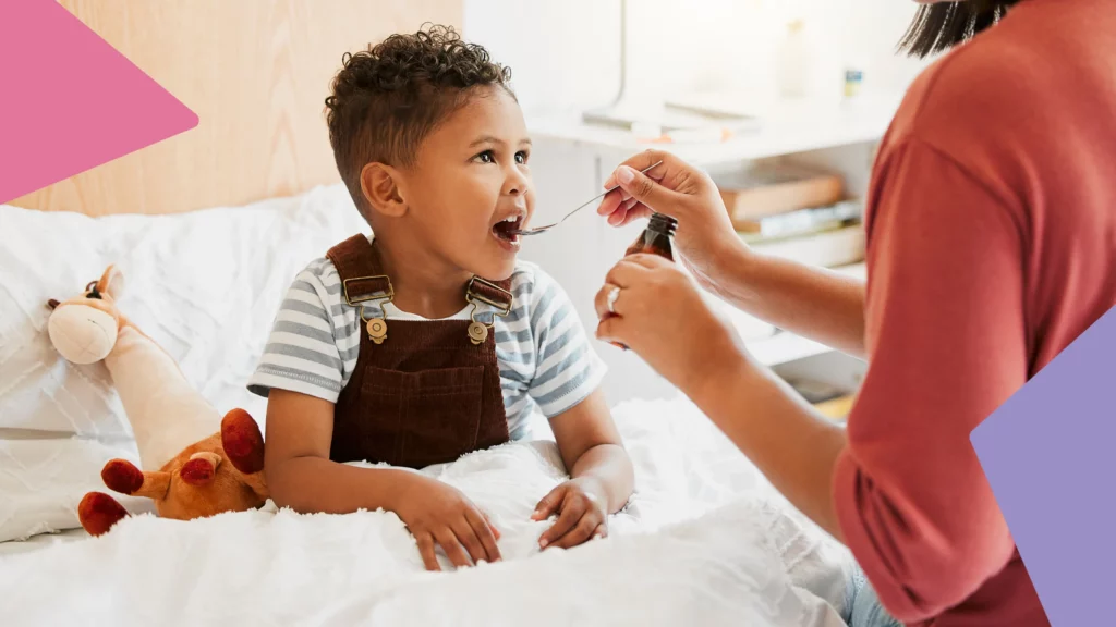 Criança abre a boca para receber medicamento na colher.
