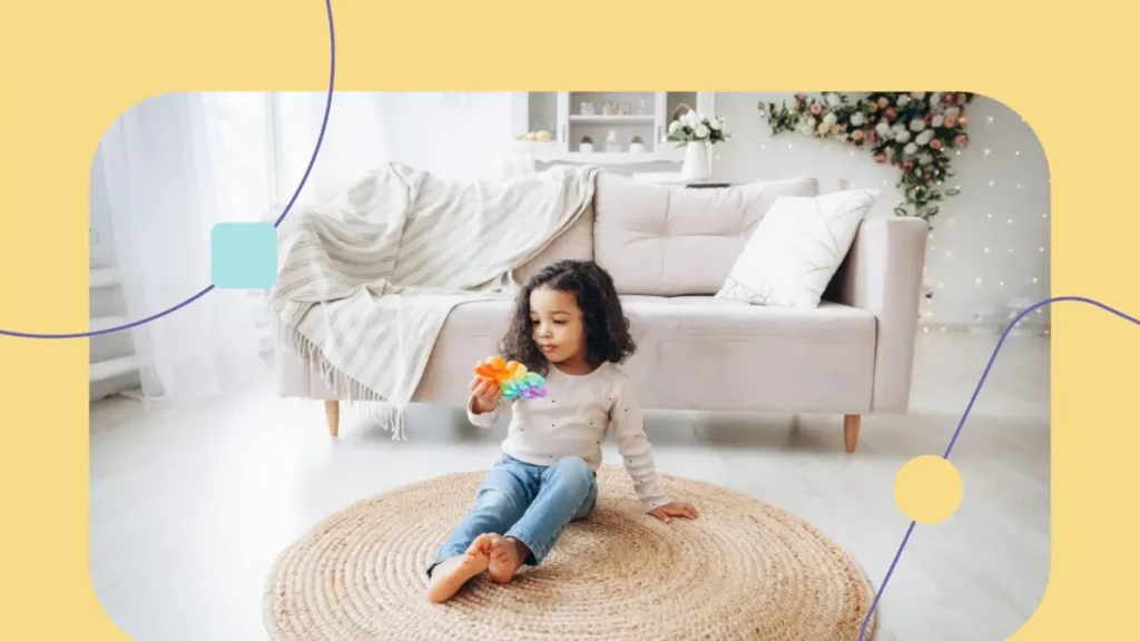 Menina brinca no tapete da sala com brinquedo sensorial de bolhas.
