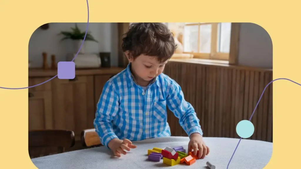 Menino com transtornos neurodivergentes. Ele está brincando com blocos coloridos.