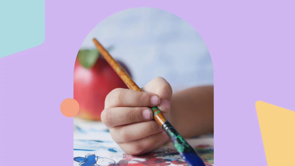 mão de uma criança pintando com pincel e tinta azul