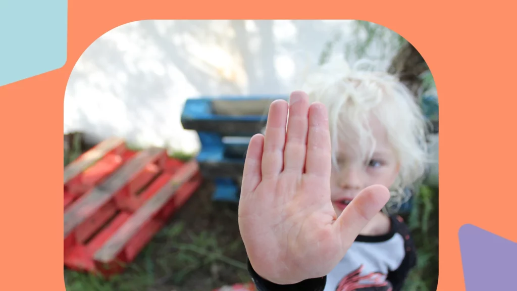 autismo e estereótipos: Criança cobre a lente da câmera com a mão.