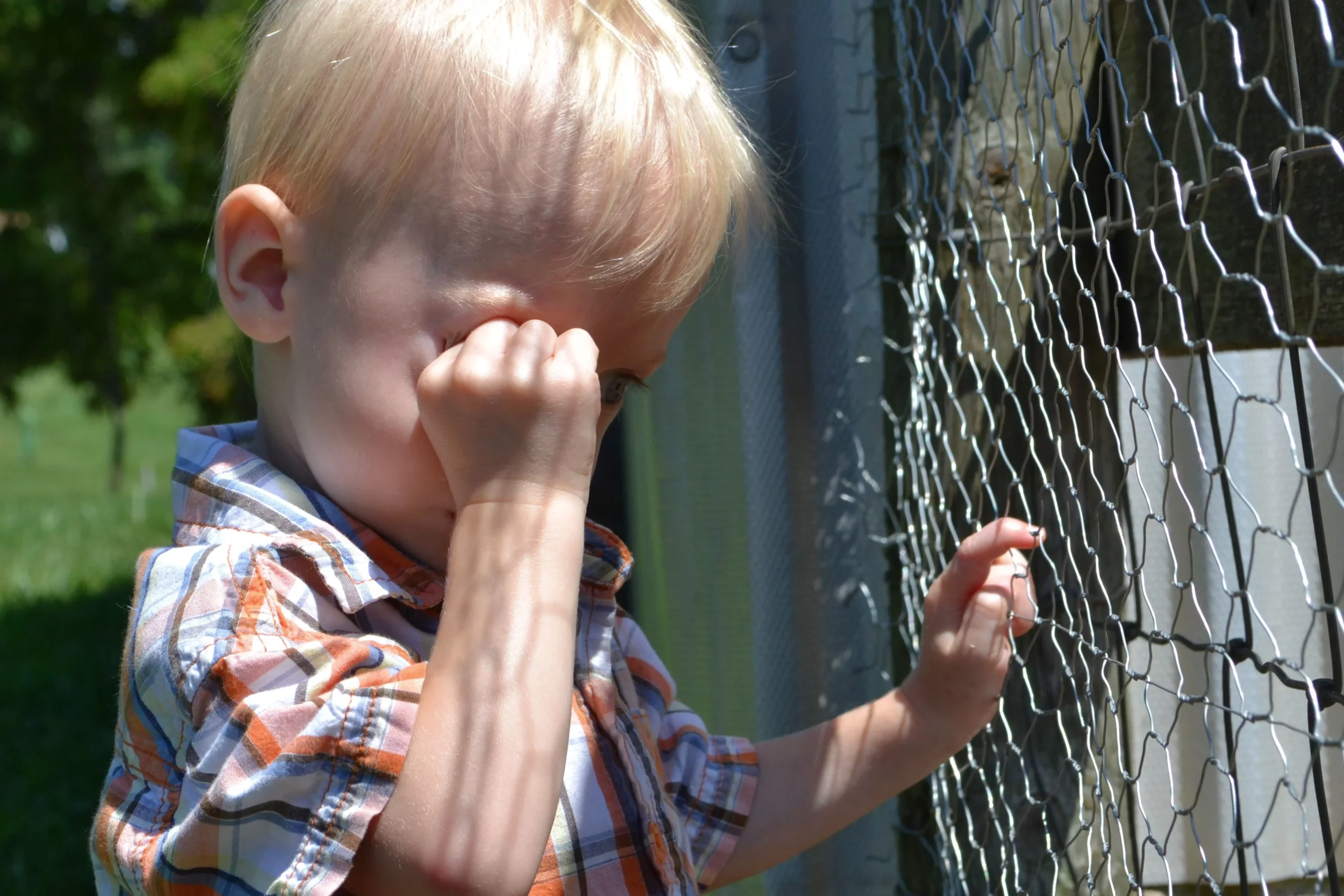 crise sensorial: menino chorando com a mão no olho 