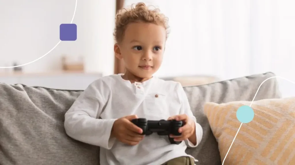 Menino jogando videogame sentado no sofá.