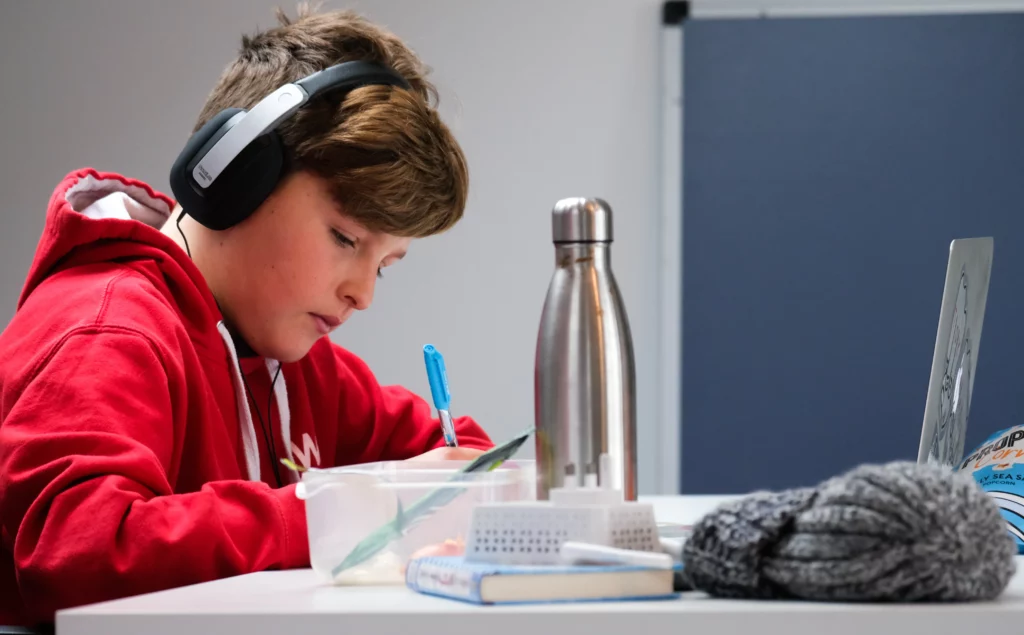 recusa escolar: menino estudando de fone de ouvidos