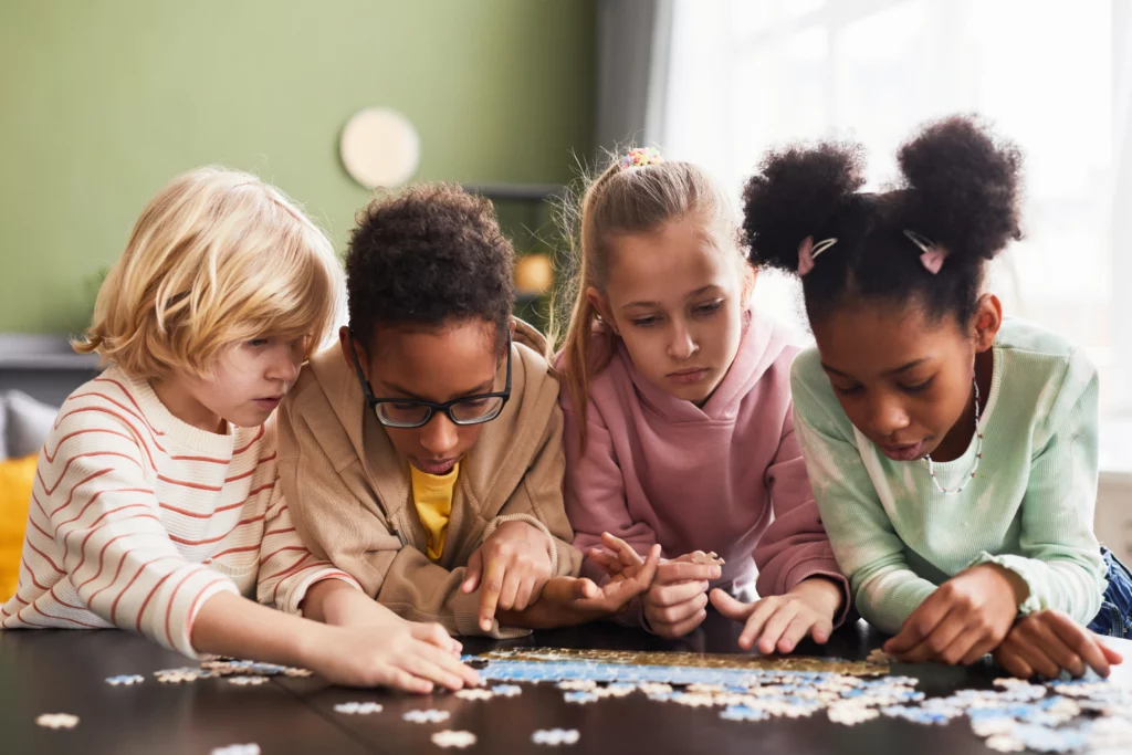 4 crianças brincando de quebra cabeça