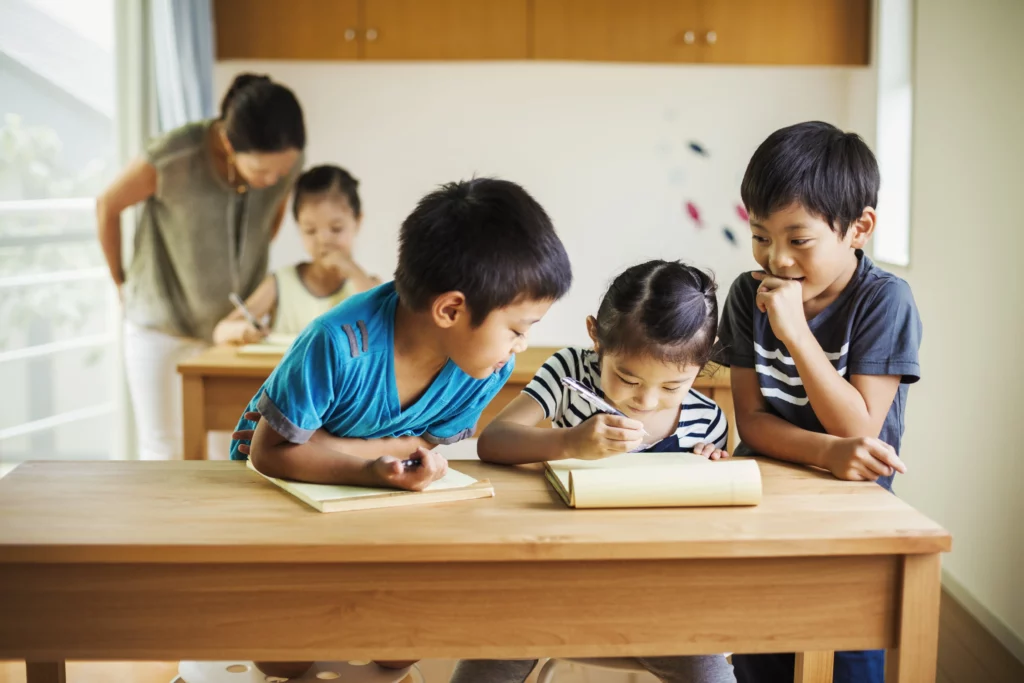 3 criança juntas em sala de aula escrevendo em um bloco de notas