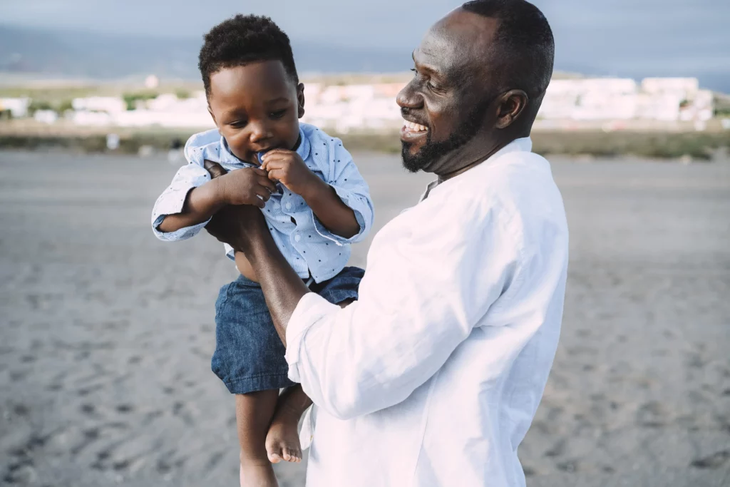 pai e filho sorrindo na praia 