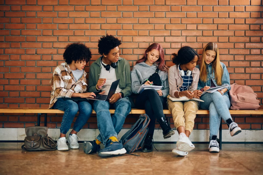 grupo de adolescentes sentados no banco da escola 