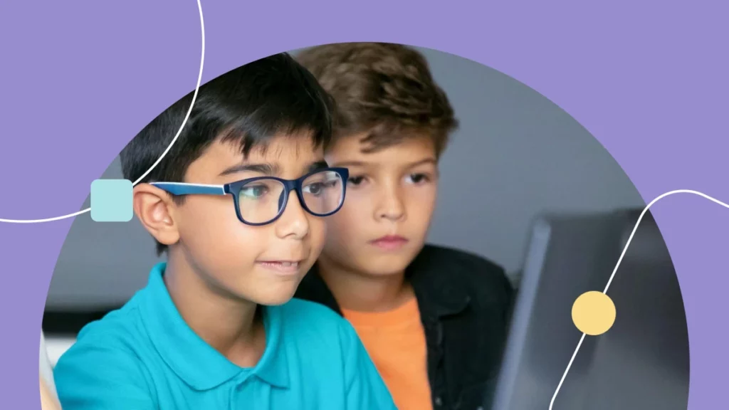 Dois meninos impressionados com um laptop. A imagem mostra como a tecnologia no autismo ajuda no desenvolvimento.