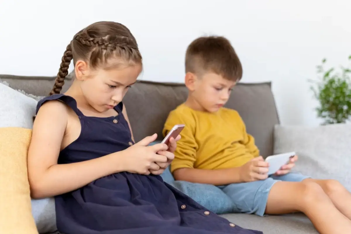 Crianças focadas em celulares. A imagem reflete ao tema: autismo virtual.