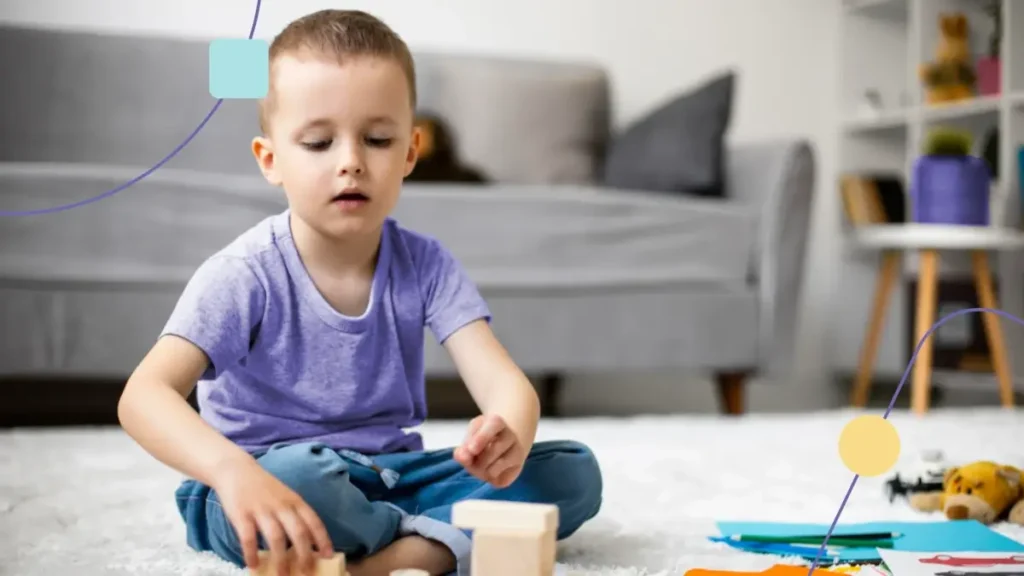 Menino brincando no chão. Essa ação ajuda na neuroplasticidade das crianças com TEA