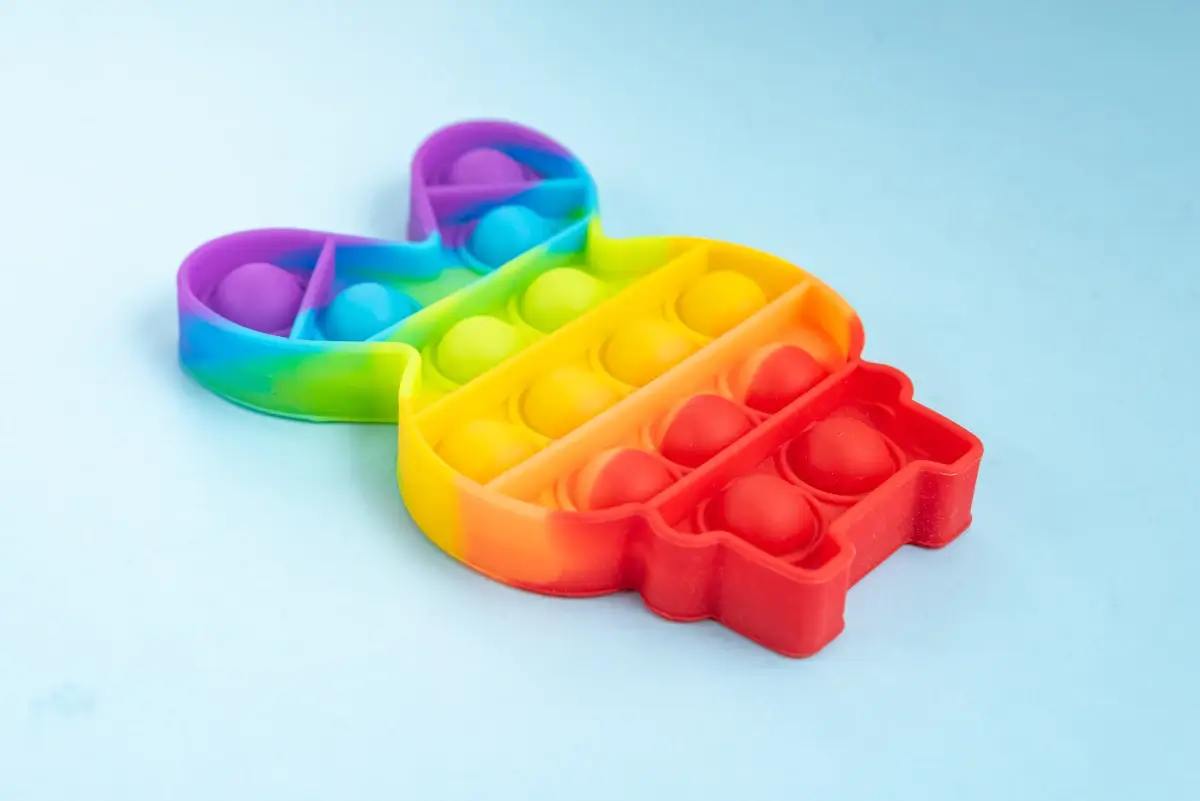 Mordedor sensorial: objeto em formato de coelho com diversas cores formando na ordem de um arco-íris