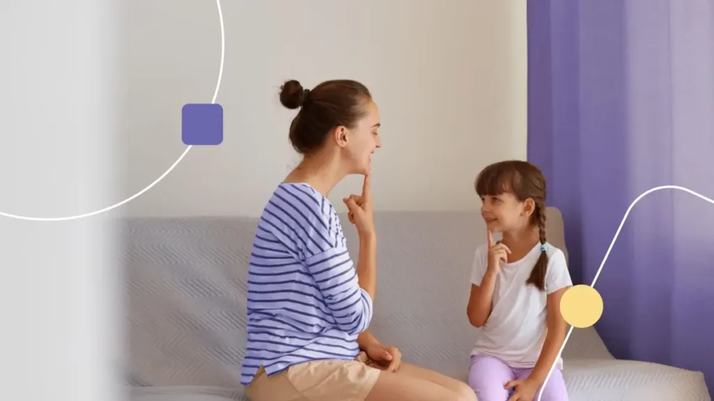 Mãe ensinando filha com técnicas de fonoaudiologia.