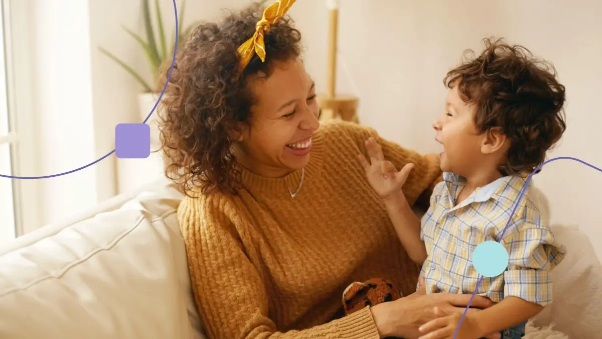 Mãe com filho no colo. Ambos sorriem e curtem o dia das mães juntos.