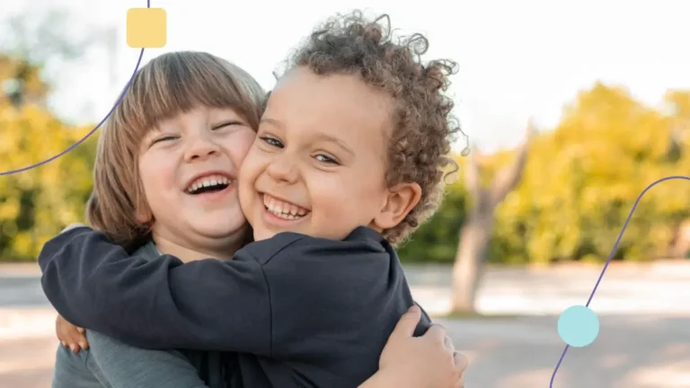 Crianças mostrando que é possível ter amizade no autismo. Ambos se abraçam sorrindo e felizes!