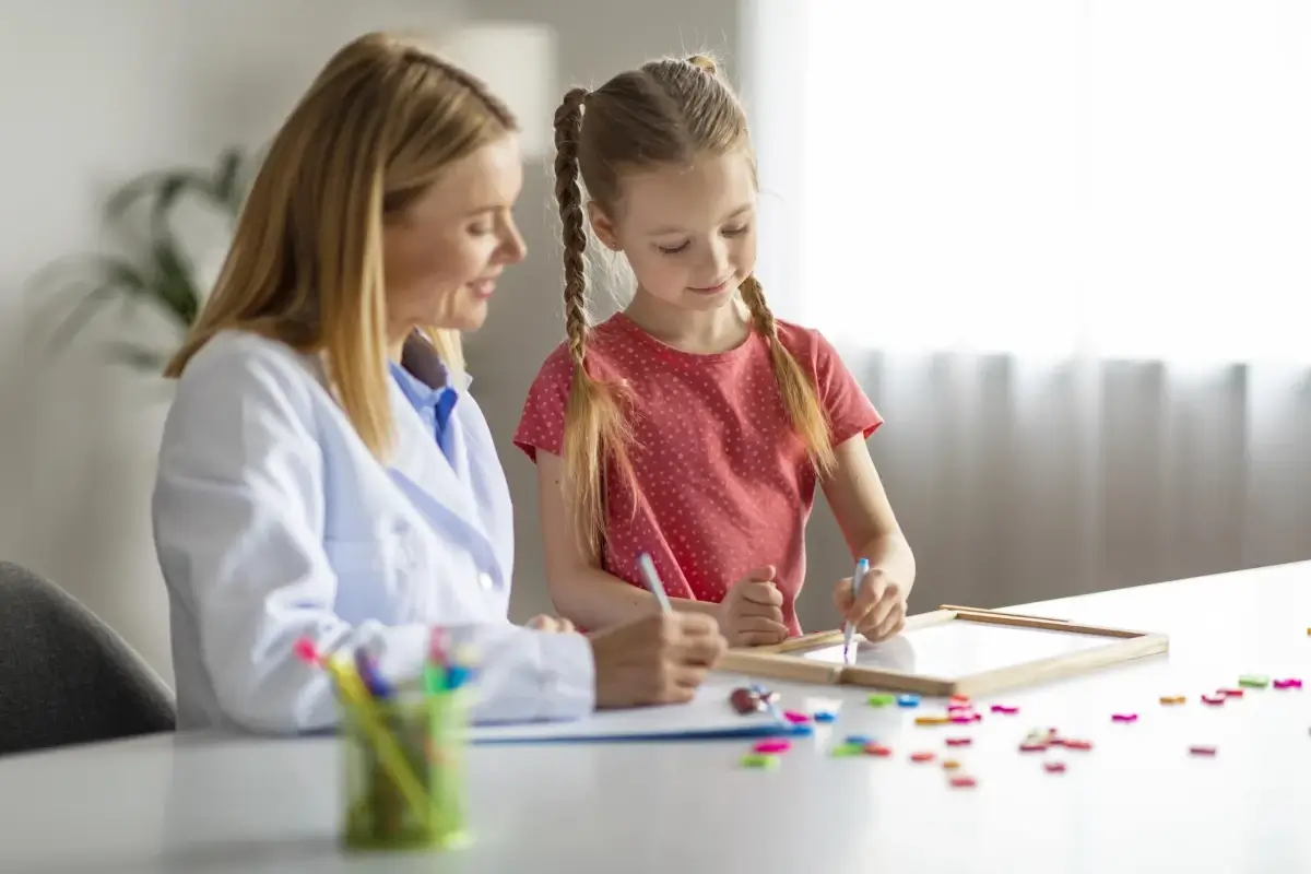 Médica usando CAA para brincar com menina com autismo