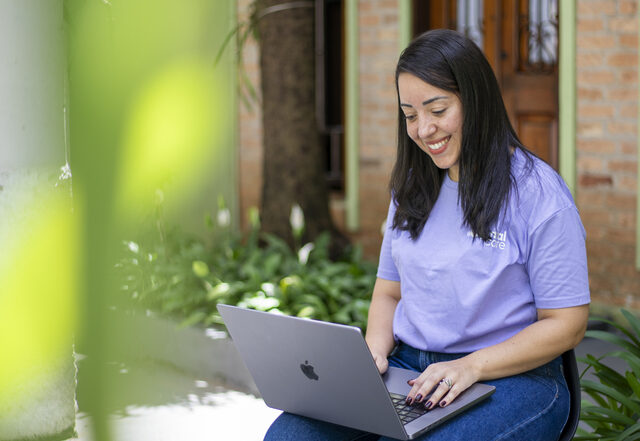 Terapeuta da Genial care sentada, olhando seu laptop