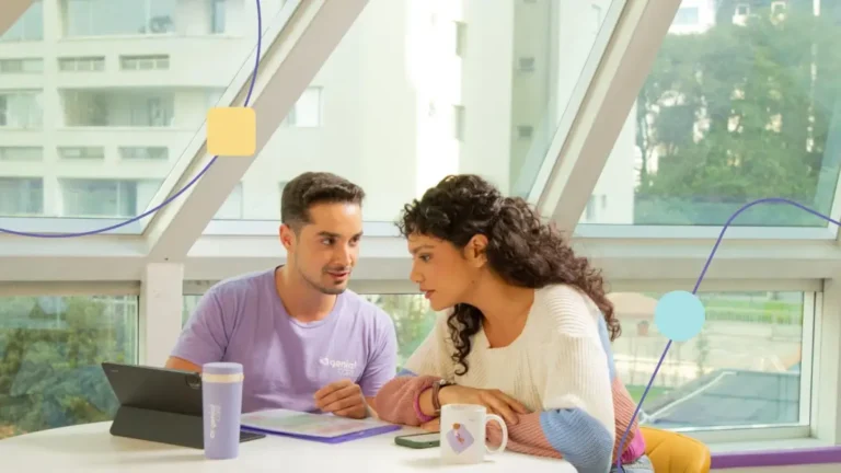 Terapeuta e mãe de filho autsta conversando sentados. Ele explica sobre integração multidisciplinar para ela.