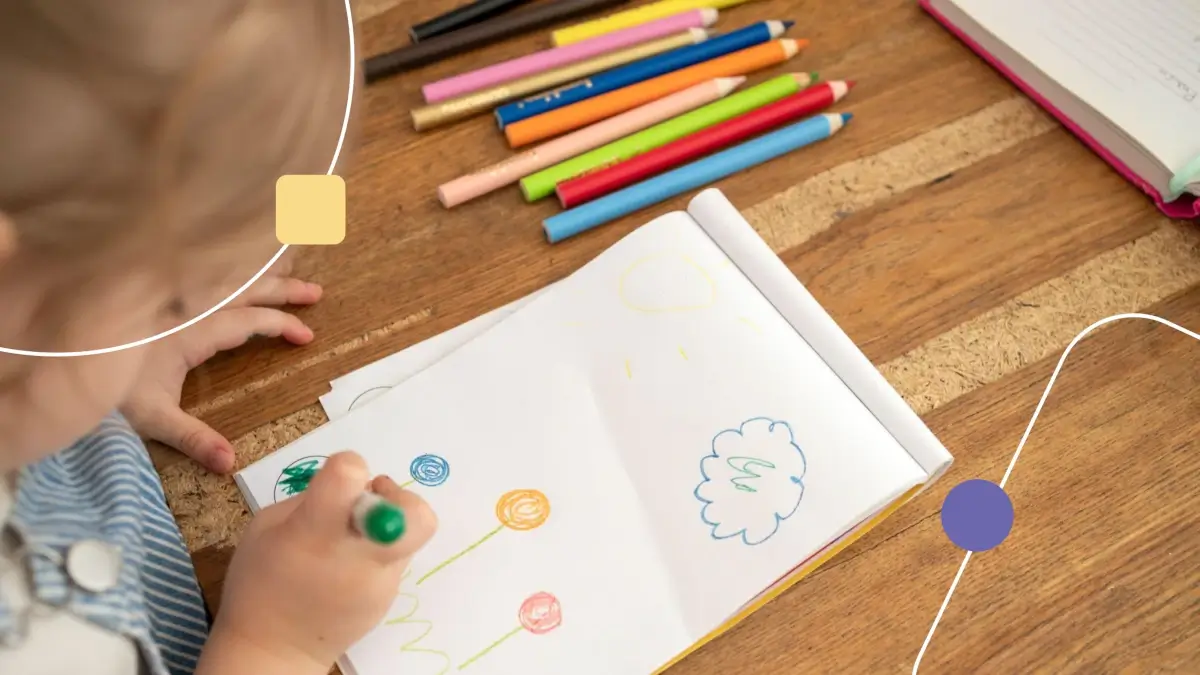 Criança participando de aula sobre pintura e autismo. Ela desenha em uma folha em branco com lápis coloridos.