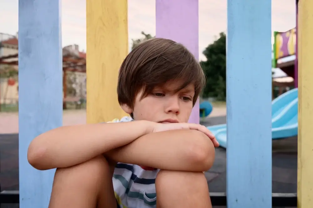 criança passando por crises no autismo. Ela se isolou no parque e preferiu ficar sozinha.