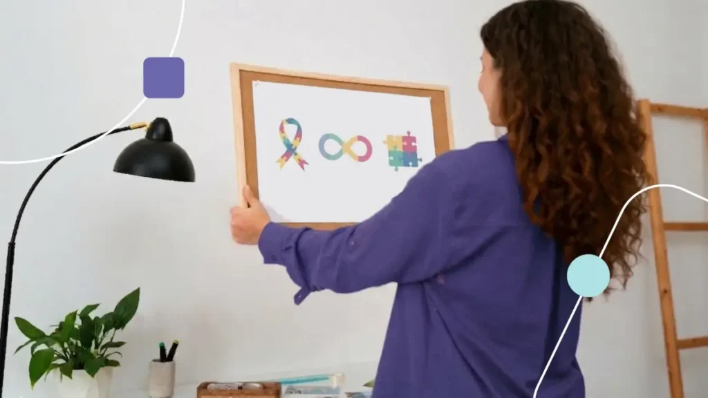 Mulher segurando um quadro com símbolos do autismo.