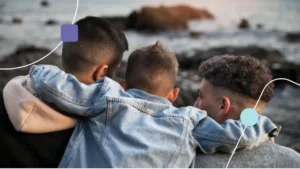 Irmãos de crianças com TEA se abraçando e olhando o mar.