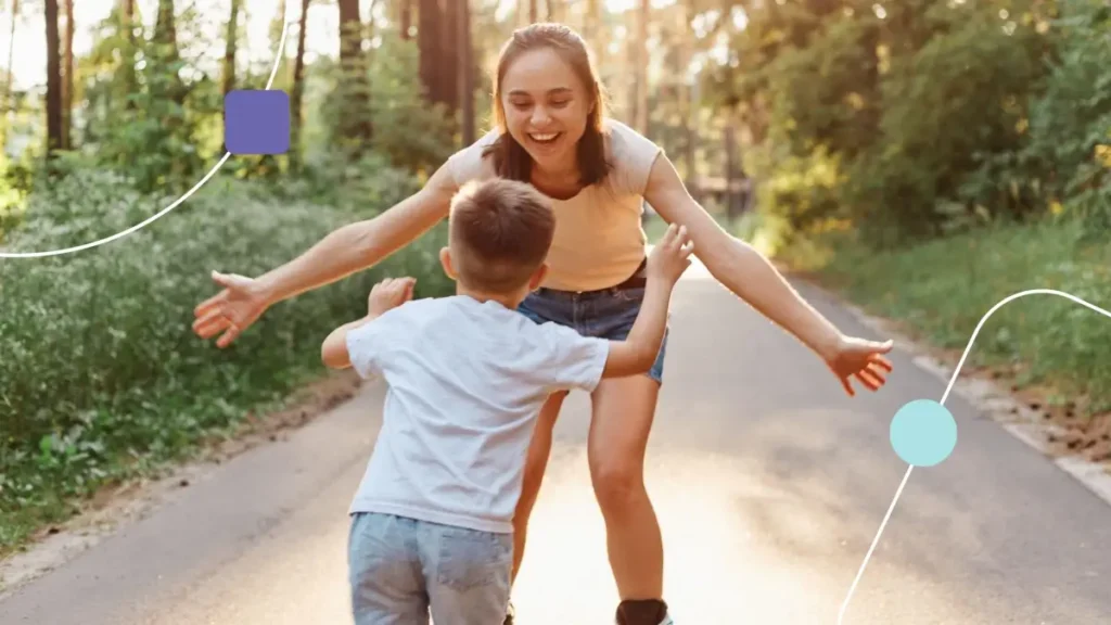 Mãe com filho proporcionando qualidade de vida na infância. Eles brincam em um parque arborizado,