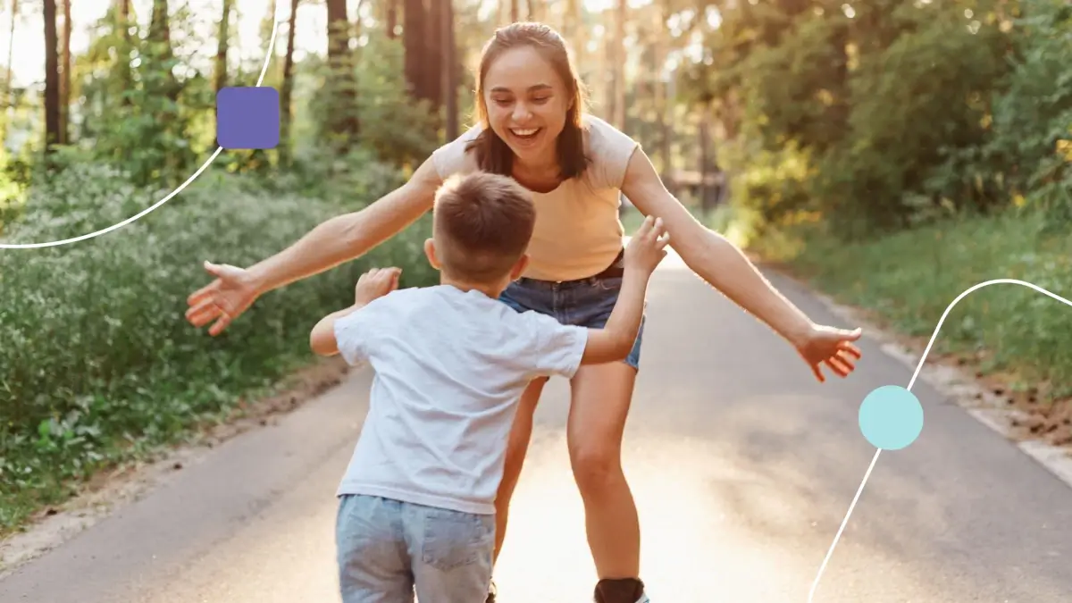 Mãe com filho proporcionando qualidade de vida na infância. Eles brincam em um parque arborizado,